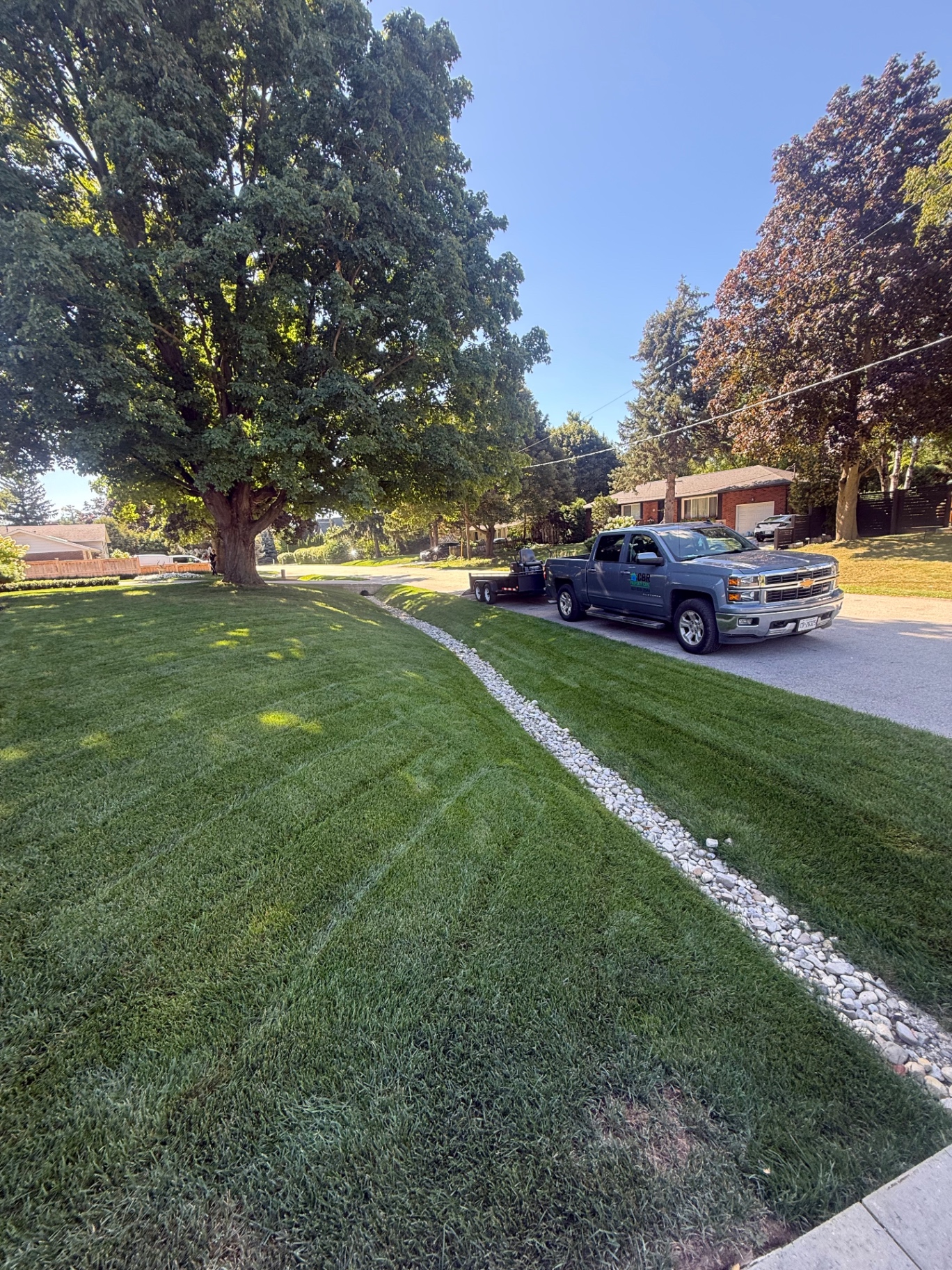 Striped front lawn with CBR truck and trailer at the curb