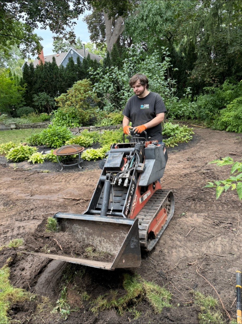 CBR crew grading a backyard with a compact track loader