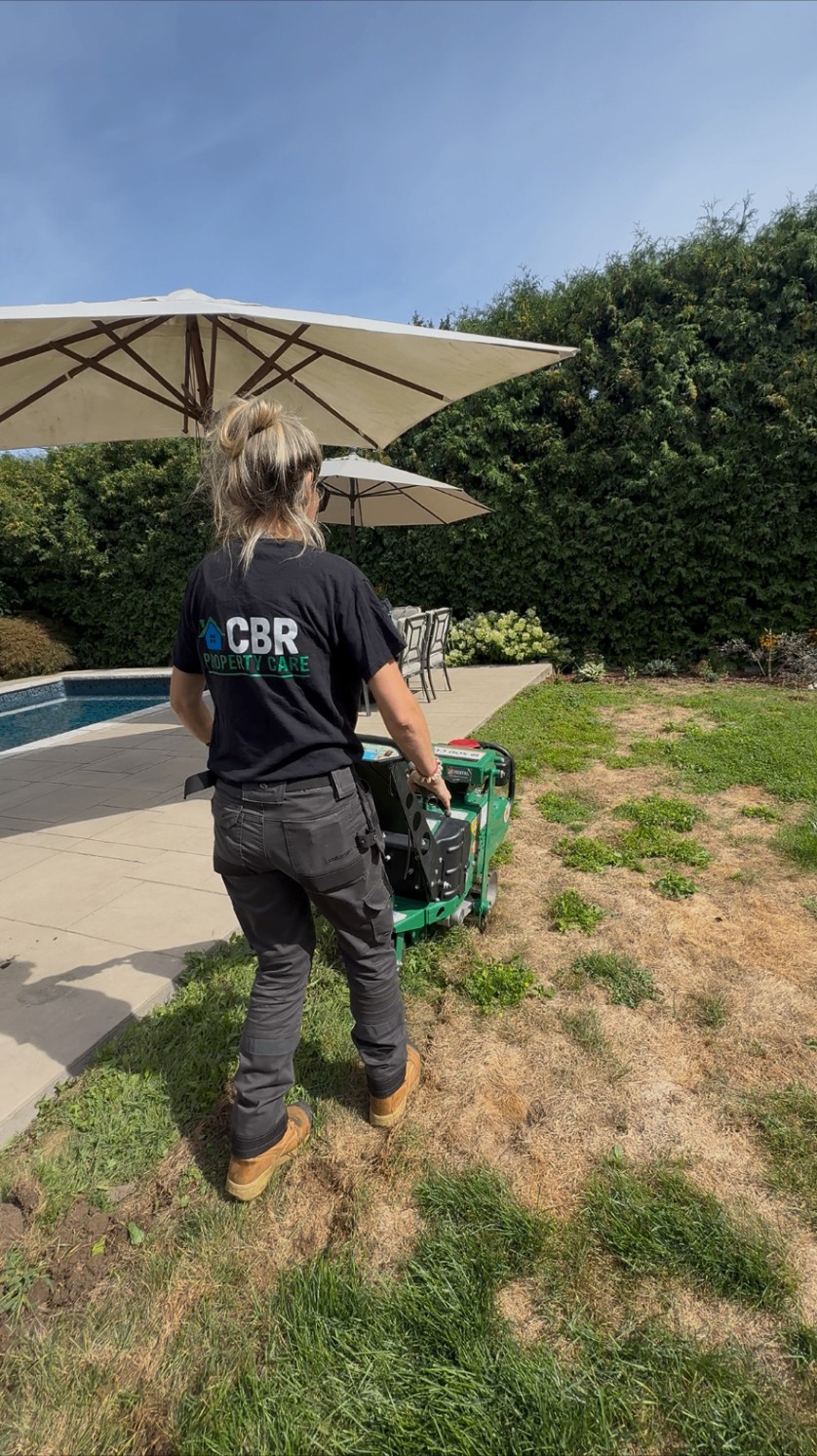 CBR crew member removing old lawn with a sod cutter beside a pool
